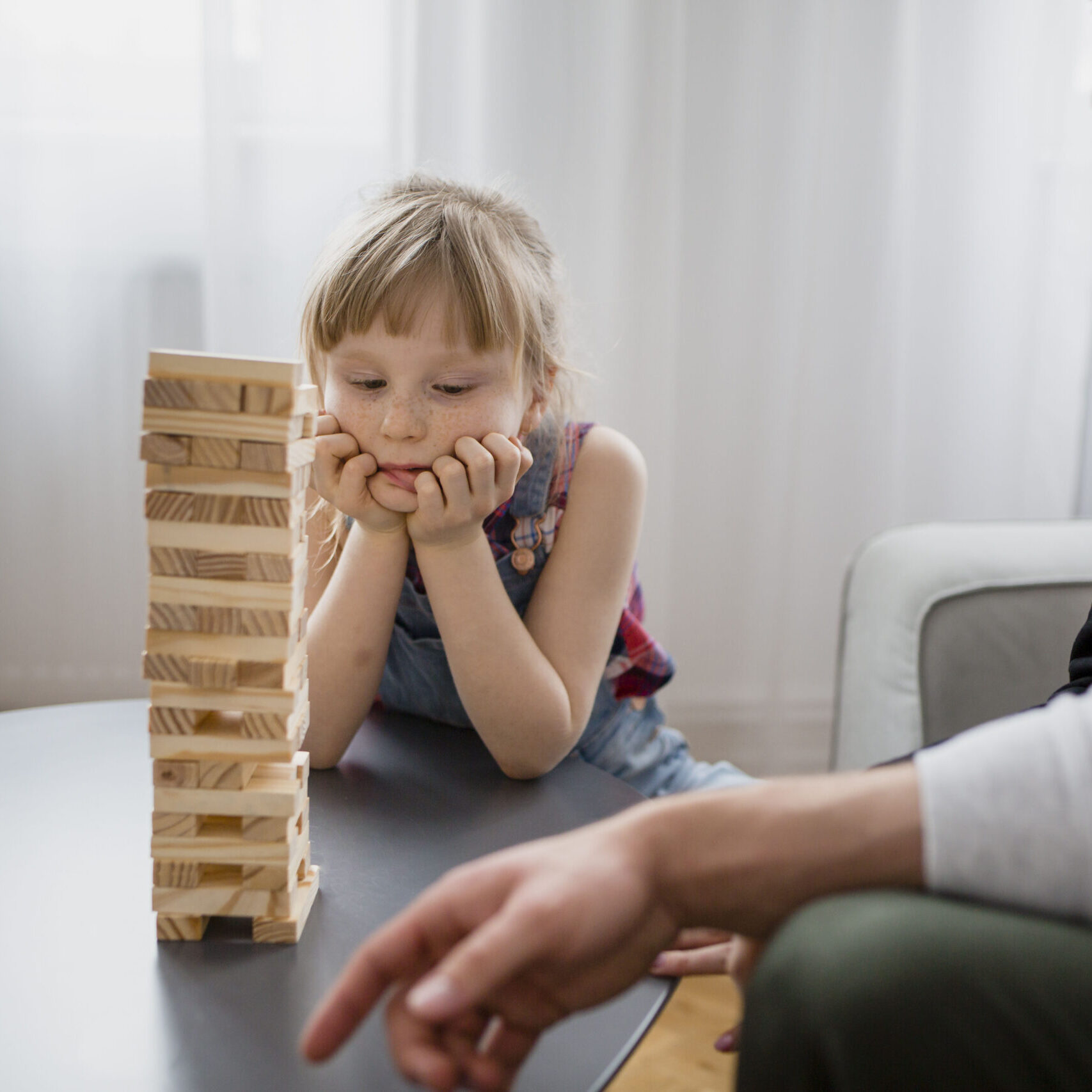 crop-parents-playing-jenga-with-daughter